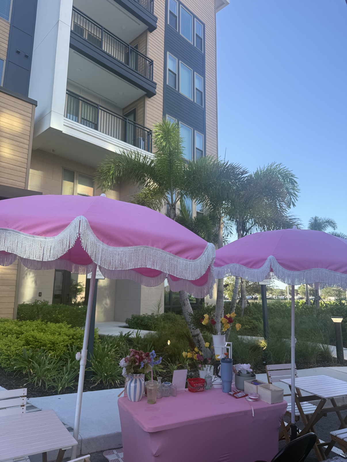 Outdoor bloom bar beneath pink-and-white market umbrellas