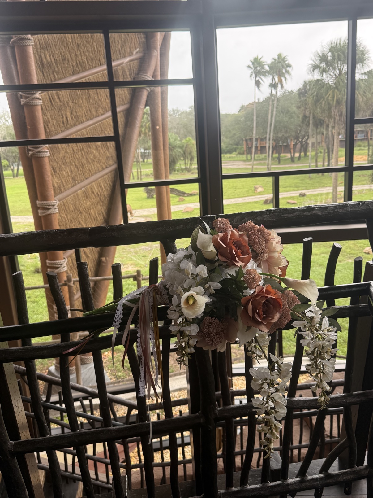 The custom faux Victorian Grande bouquet resting on a railing overlooking the savanna at Disney's Animal Kingdom Lodge